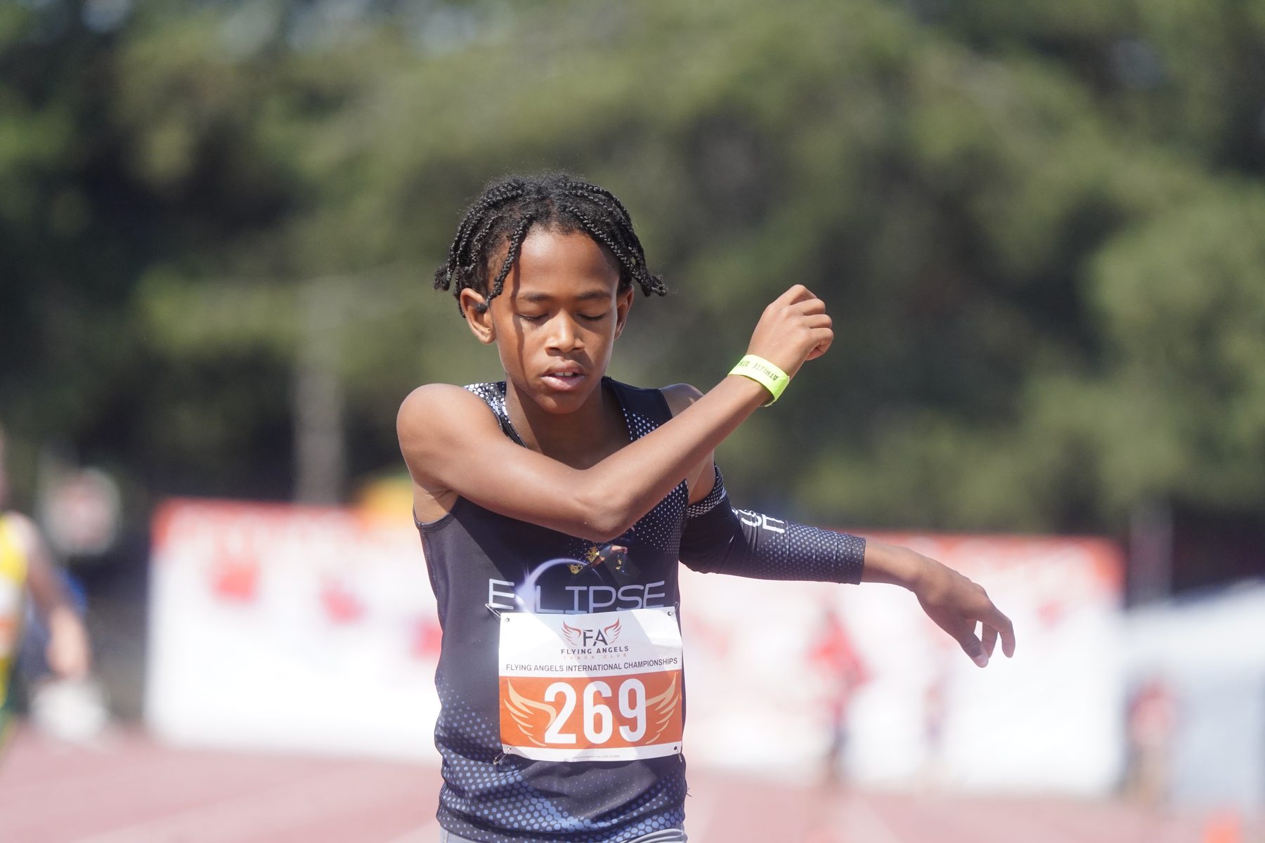Young athlete sprinting, braids flying