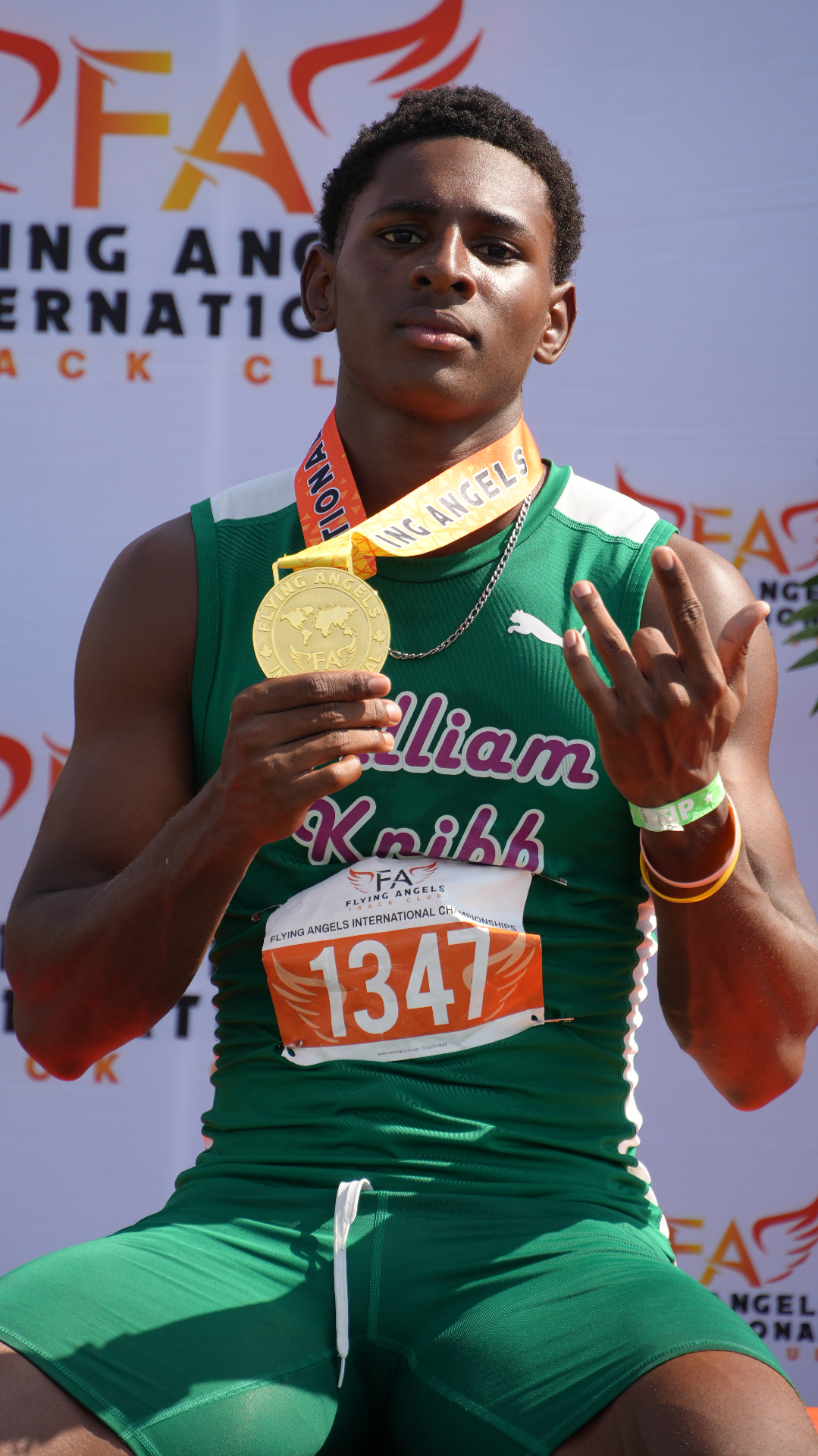 William Knibb athlete on the podium with gold medal